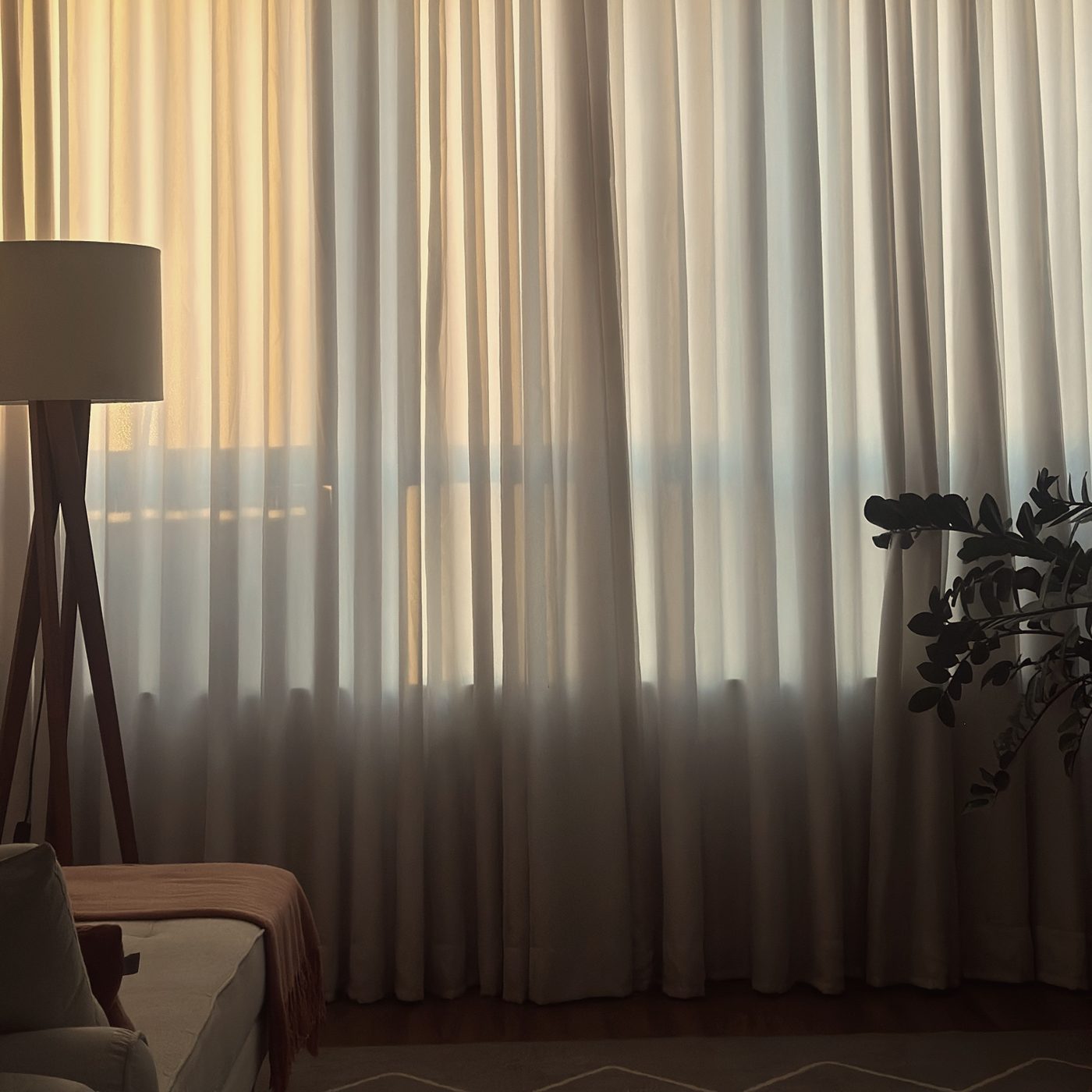 Luz da tarde atravessando a cortina do consultório, com a luminária e o divã
